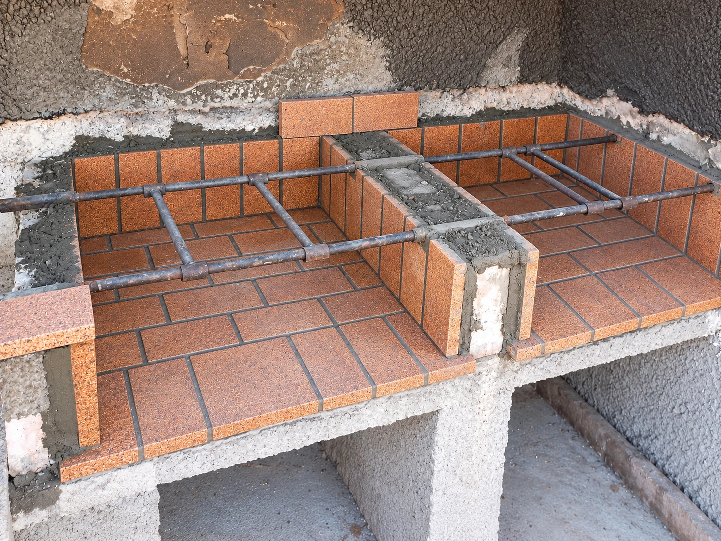 Paellero de obra en ejecución, con piezas cerámicas y mortero a la vista